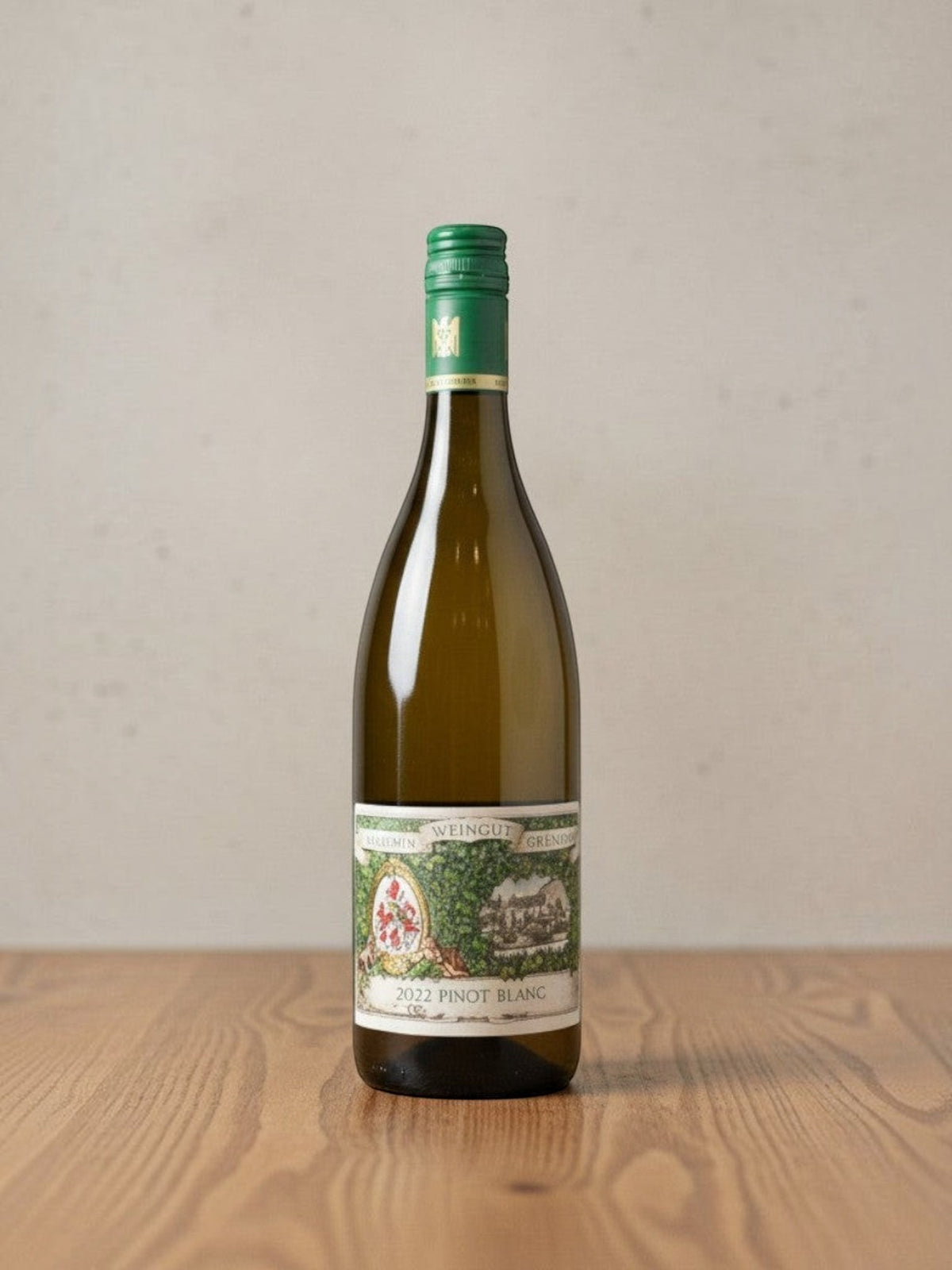 Goldener Zwilling Maximin Grünhaus Pinot Blanc 2022 Weißweinflasche mit grünem Schraubverschluss auf Holztisch
