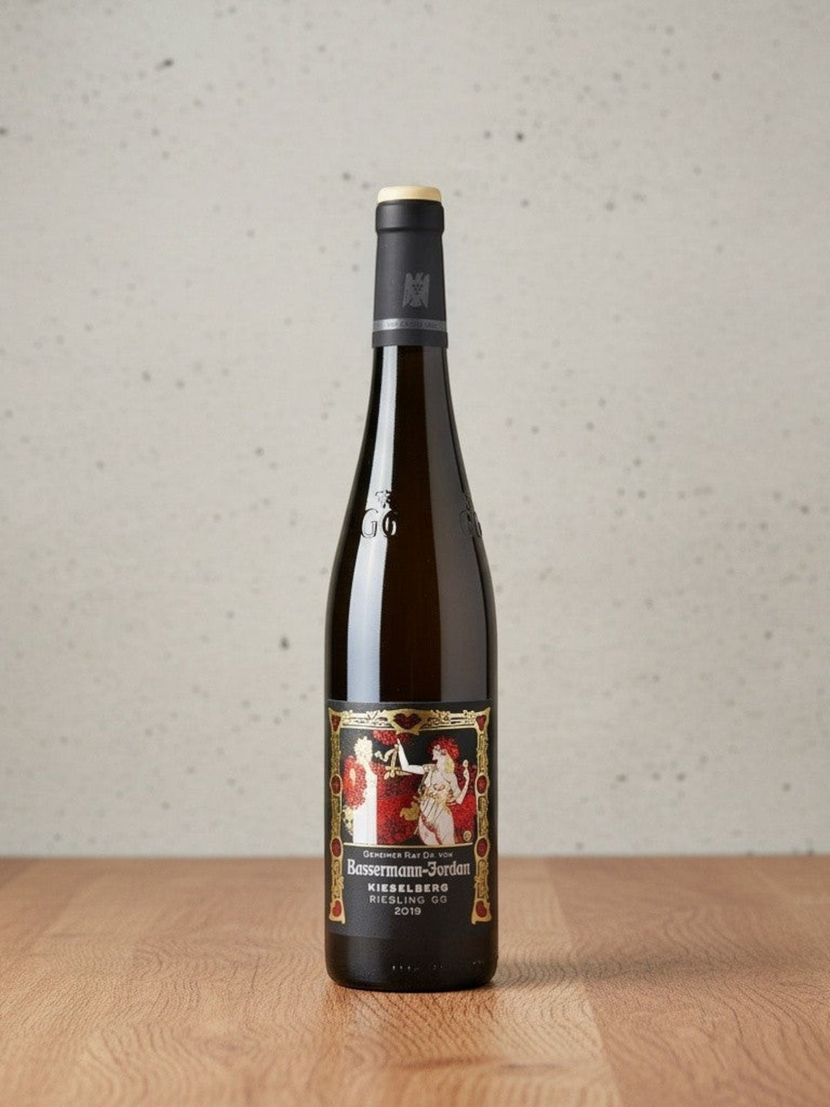 Goldener Zwilling Bassermann-Jordan Kieselberg GG 2019 Riesling Flasche mit kunstvollem Etikett auf Holztisch