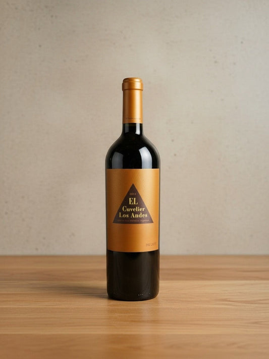 Goldener Zwilling Cuvelier los Andes EL 2013 Rotweinflasche mit goldenem Etikett auf einem Holztisch