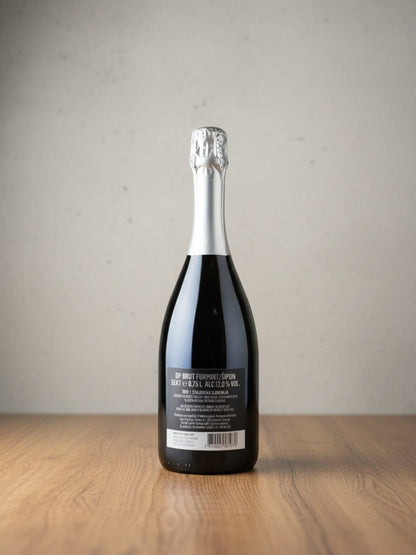 Rückseite einer Goldener Zwilling Dveri-Pax Furmint Brut 2019 Sektflasche mit Etikett auf einem Holztisch