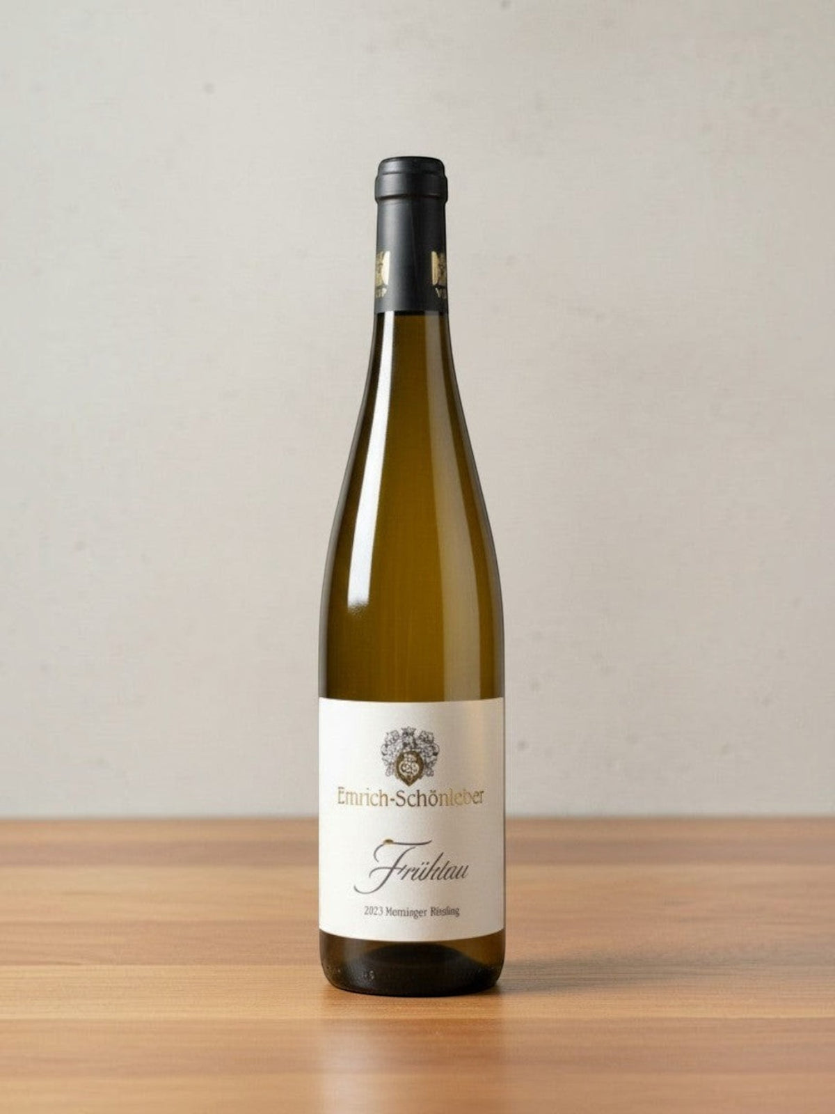 Goldener Zwilling Emrich-Schönleber Monzinger Frühtau Riesling 2023 in einer eleganten Weinflasche auf Holztisch
