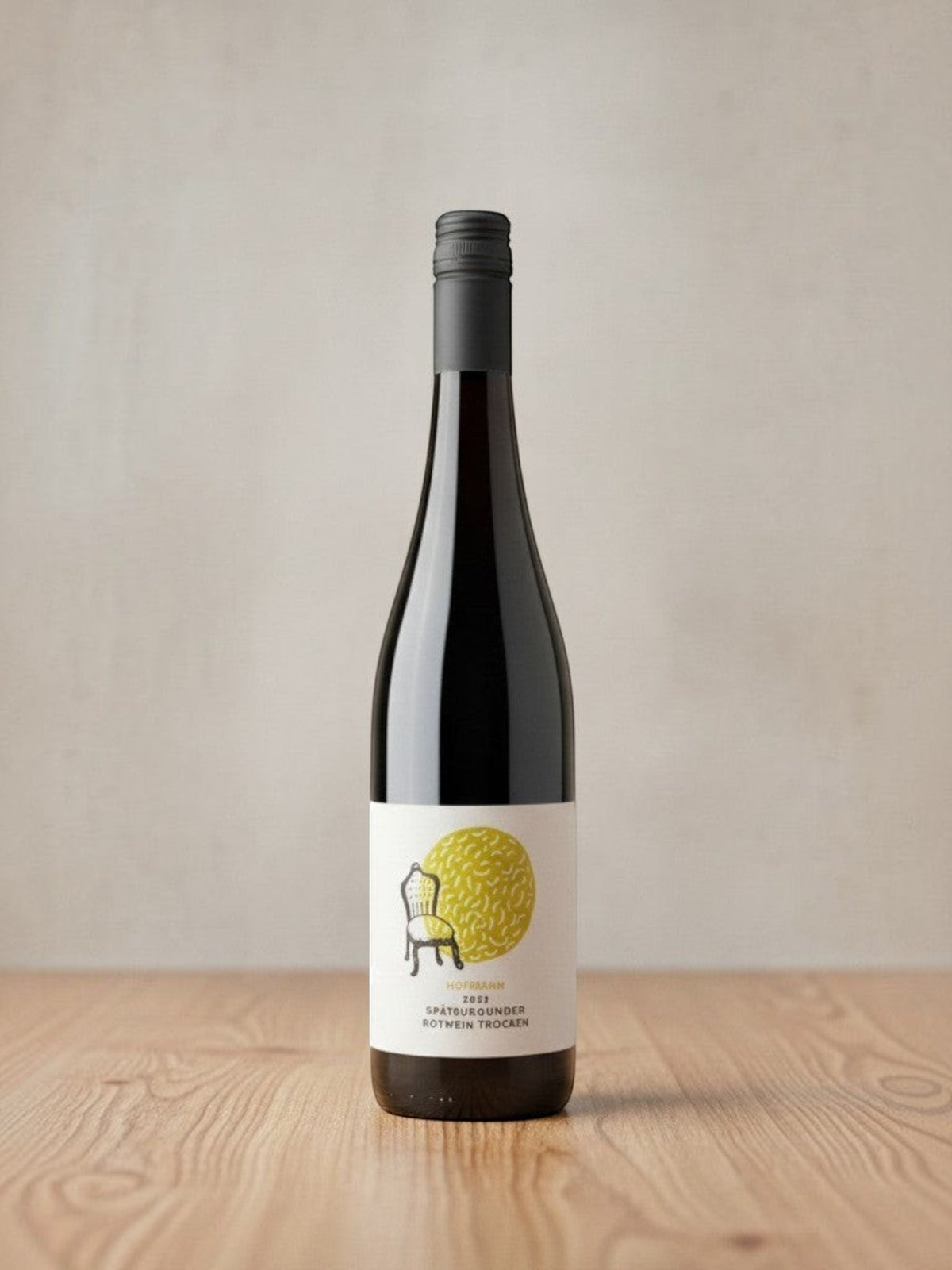 Goldener Zwilling Hofmann Spätburgunder trocken 2022 Bio-Rotwein in einer eleganten Weinflasche auf Holztisch