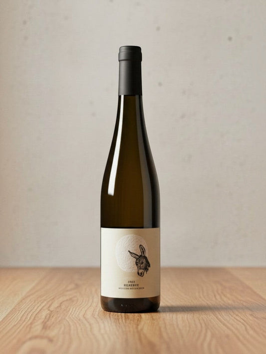 Goldener Zwilling Hofmann Weißer Burgunder Reserve BIO 2022 Weißweinflasche mit Esel-Etikett auf Holztisch