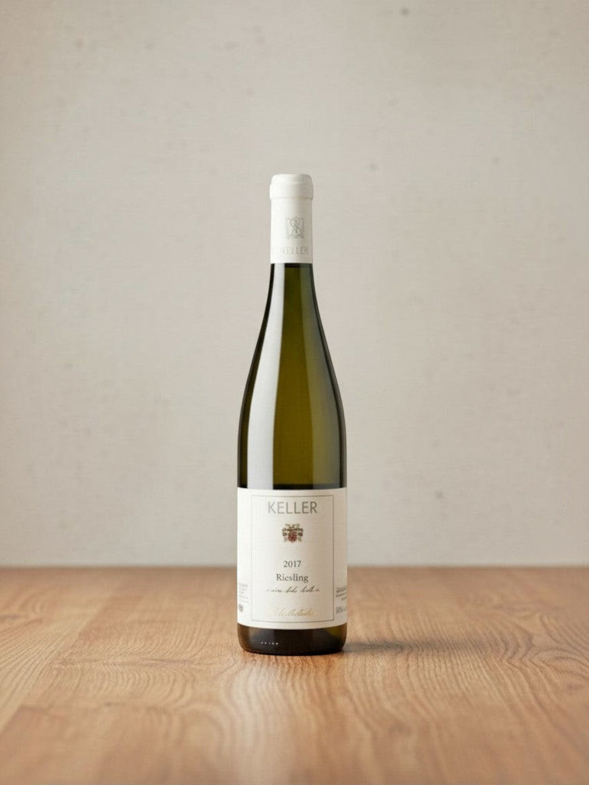 Goldener Zwilling Keller von der Fels 2017 Riesling Weißweinflasche auf einem Holztisch vor neutralem Hintergrund