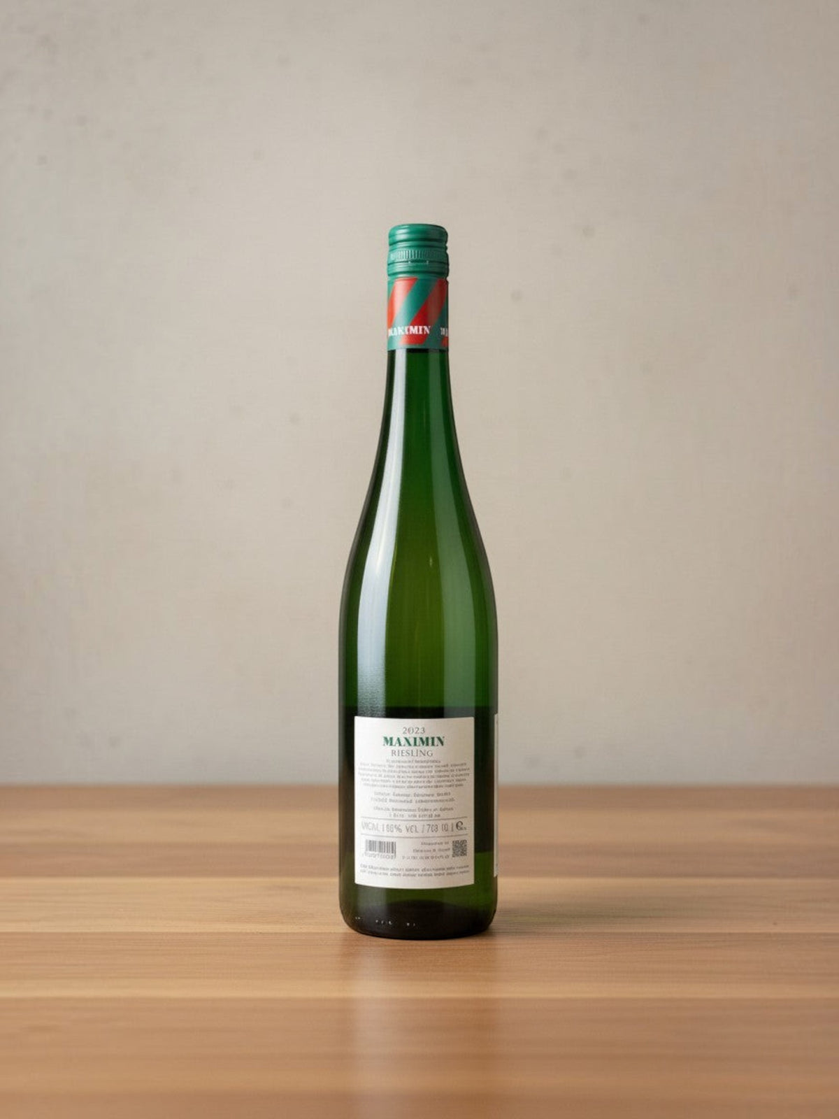 Goldener Zwilling Maximin Grünhaus Riesling Maximin feinherb 2023 Weinflasche mit grünem Etikett auf Holztisch