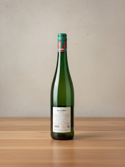 Goldener Zwilling Maximin Grünhaus Riesling Maximin feinherb 2023 Weinflasche mit grünem Etikett auf Holztisch