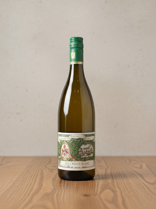 Goldener Zwilling Maximin Grünhaus Pinot Blanc 2022 Weißweinflasche mit grünem Schraubverschluss auf Holztisch