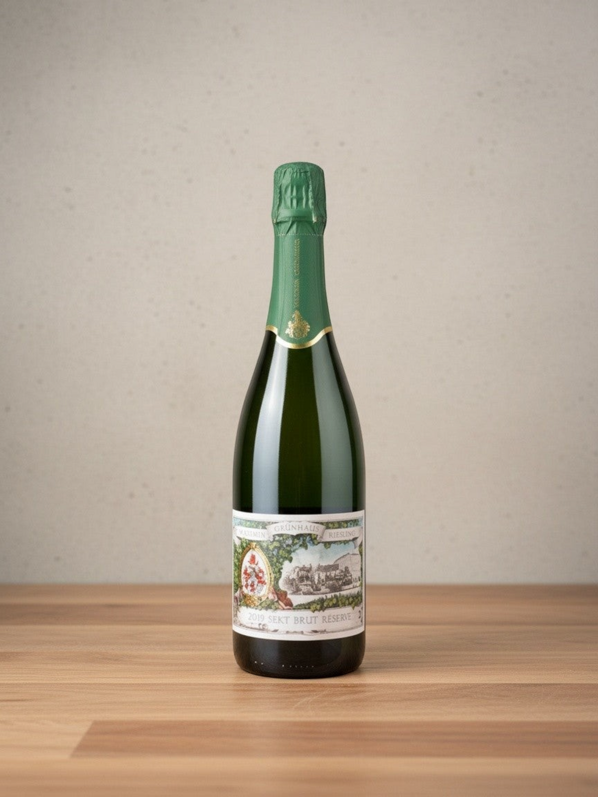 Goldener Zwilling Maximin Grünhaus Riesling Sekt brut Réserve 2019 Flasche mit grünem Verschluss auf Holztisch