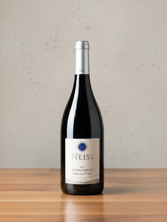 Goldener Zwilling Neiss Cabernet Franc Sonnenberg 2020 Rotweinflasche auf einem Holztisch vor neutralem Hintergrund